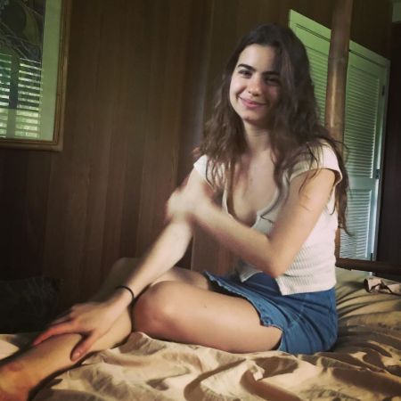 Ballerina dancer Violetta Komyshan in a brown top and jeans shorts poses a picture.
